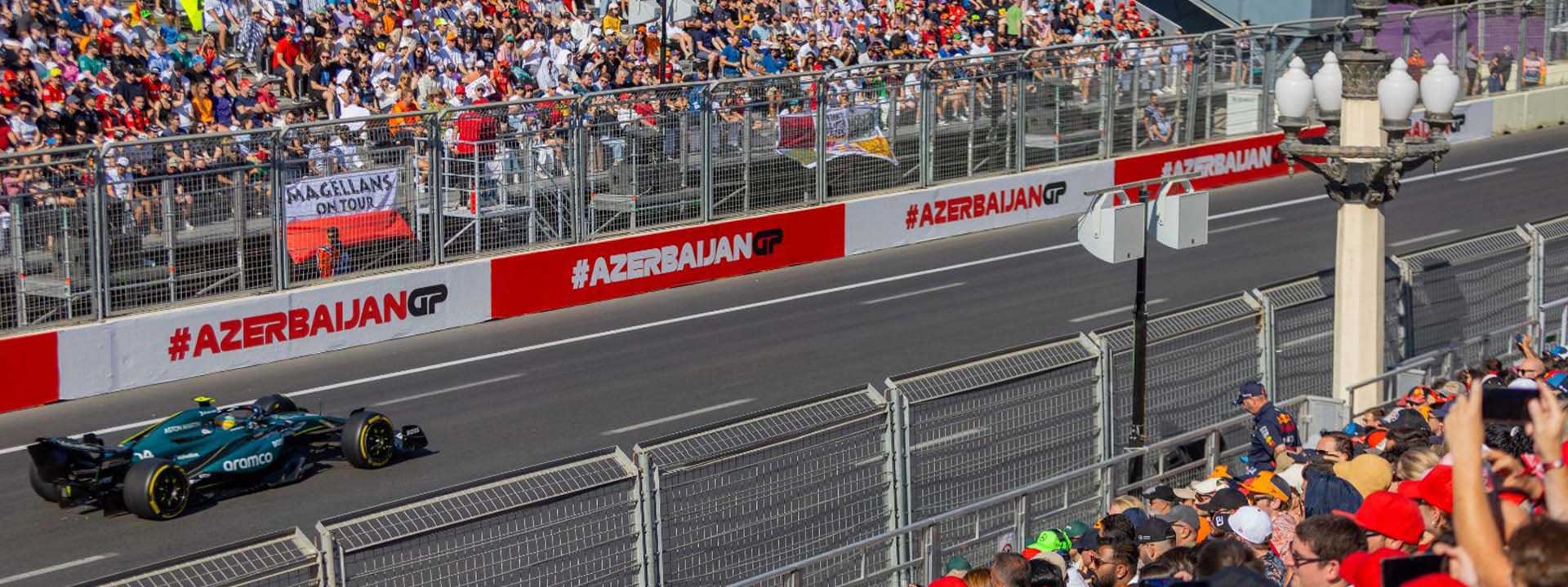 Гоночная машина на трассе, вокруг болельщики