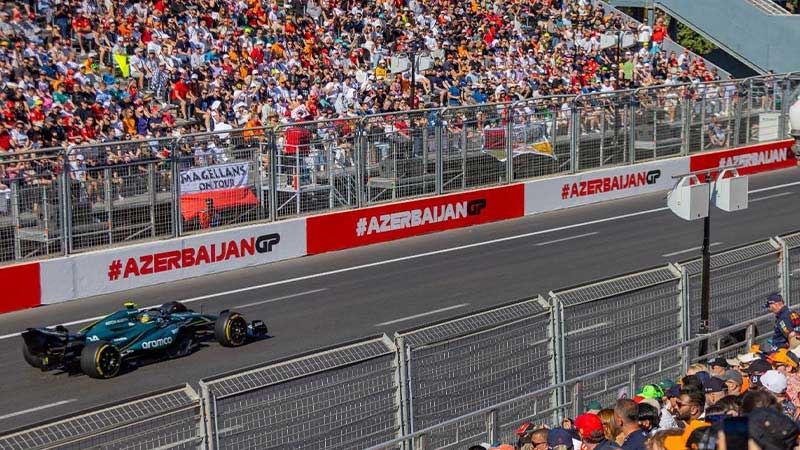 Гоночная машина на трассе, вокруг болельщики