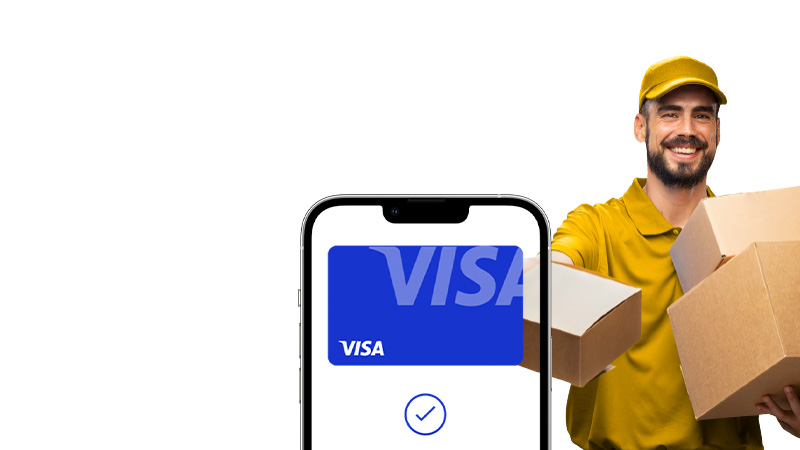 A smiling delivery person in a yellow uniform holds two cardboard boxes. A smartphone screen with a VISA logo and a confirmation check mark is in the foreground.