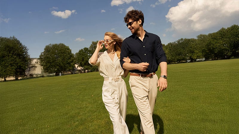 A woman holds her man by the hand on a walk